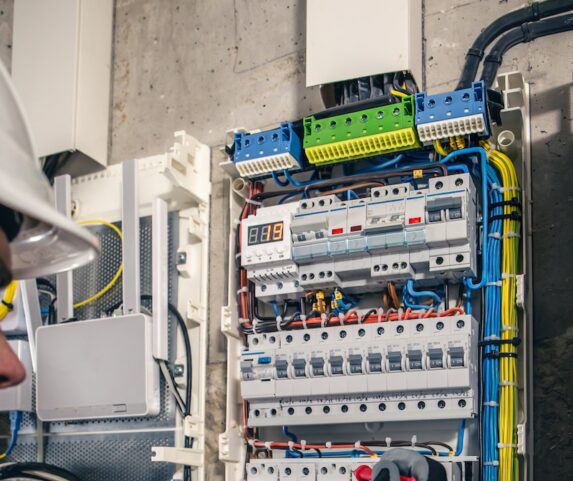 Man, an electrical technician working in a switchboard with fuses.